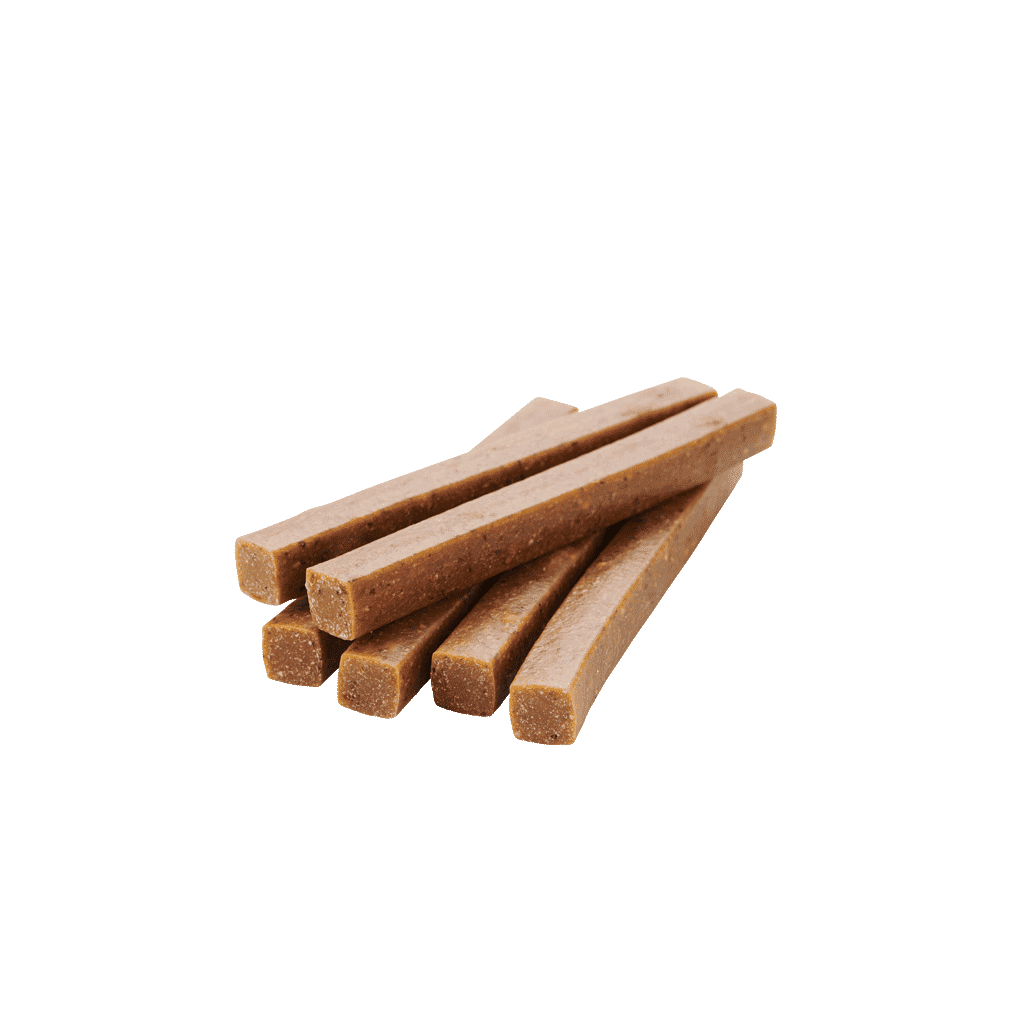 Mehrere braune Veggie-Snack Sticks für Hunde mit Kelp-Alge, lose auf weißem Hintergrund angeordnet