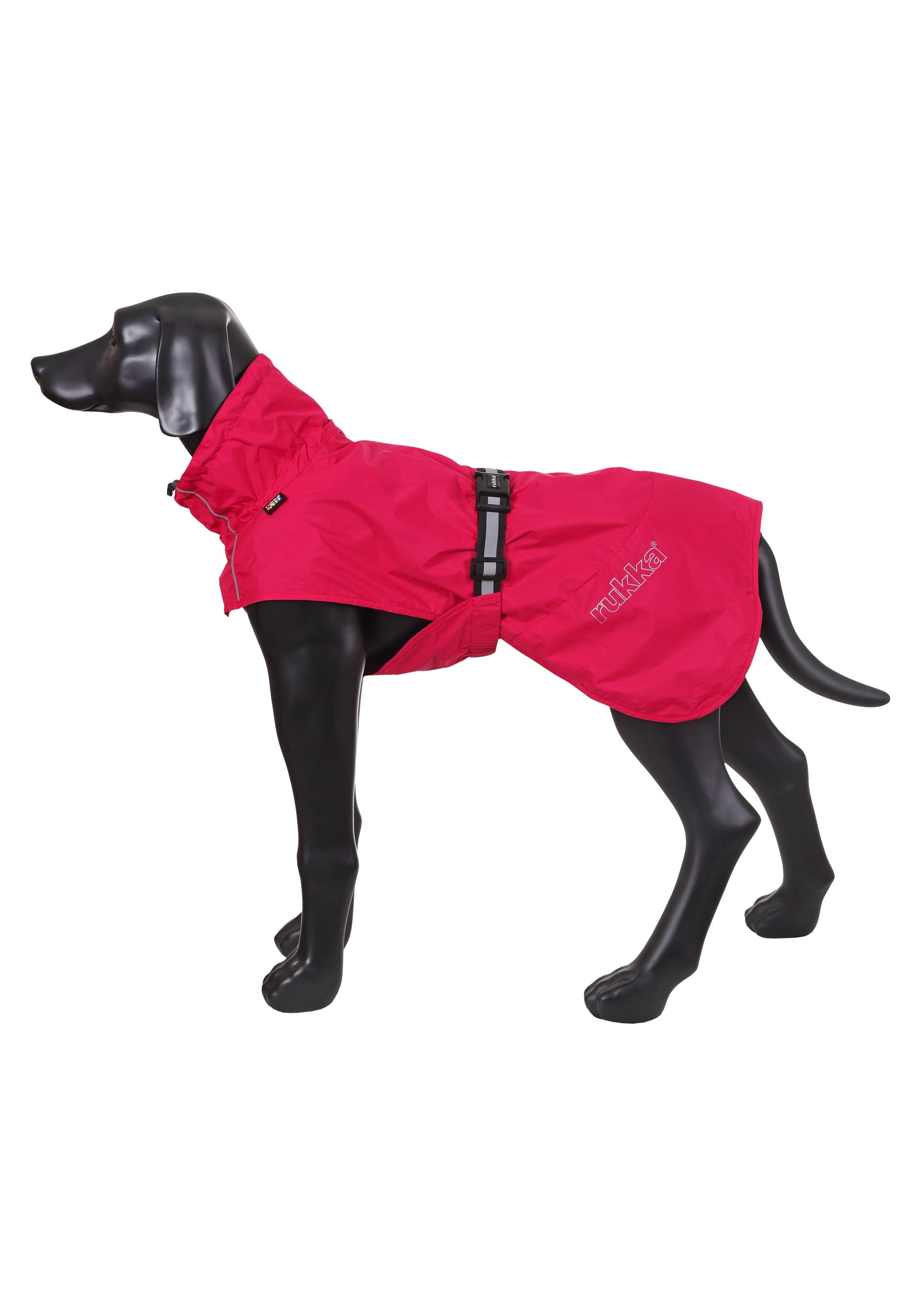 Hund steht seitlich im RukkaPets Regenmantel Hase in Rot, mit reflektierenden Details und sicherem Sitz.