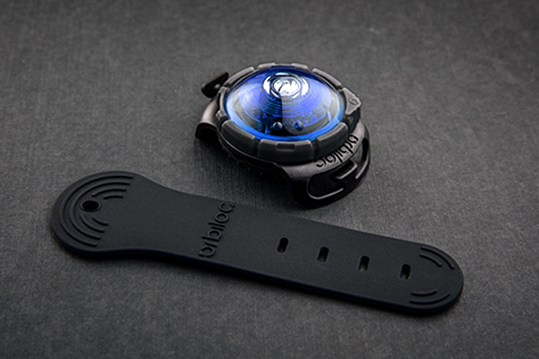 Blau leuchtendes Orbiloc Sicherheitslicht mit schwarzem Befestigungsband auf dunklem Untergrund, ideal zur sicheren Sichtbarkeit von Hunden bei Nacht.