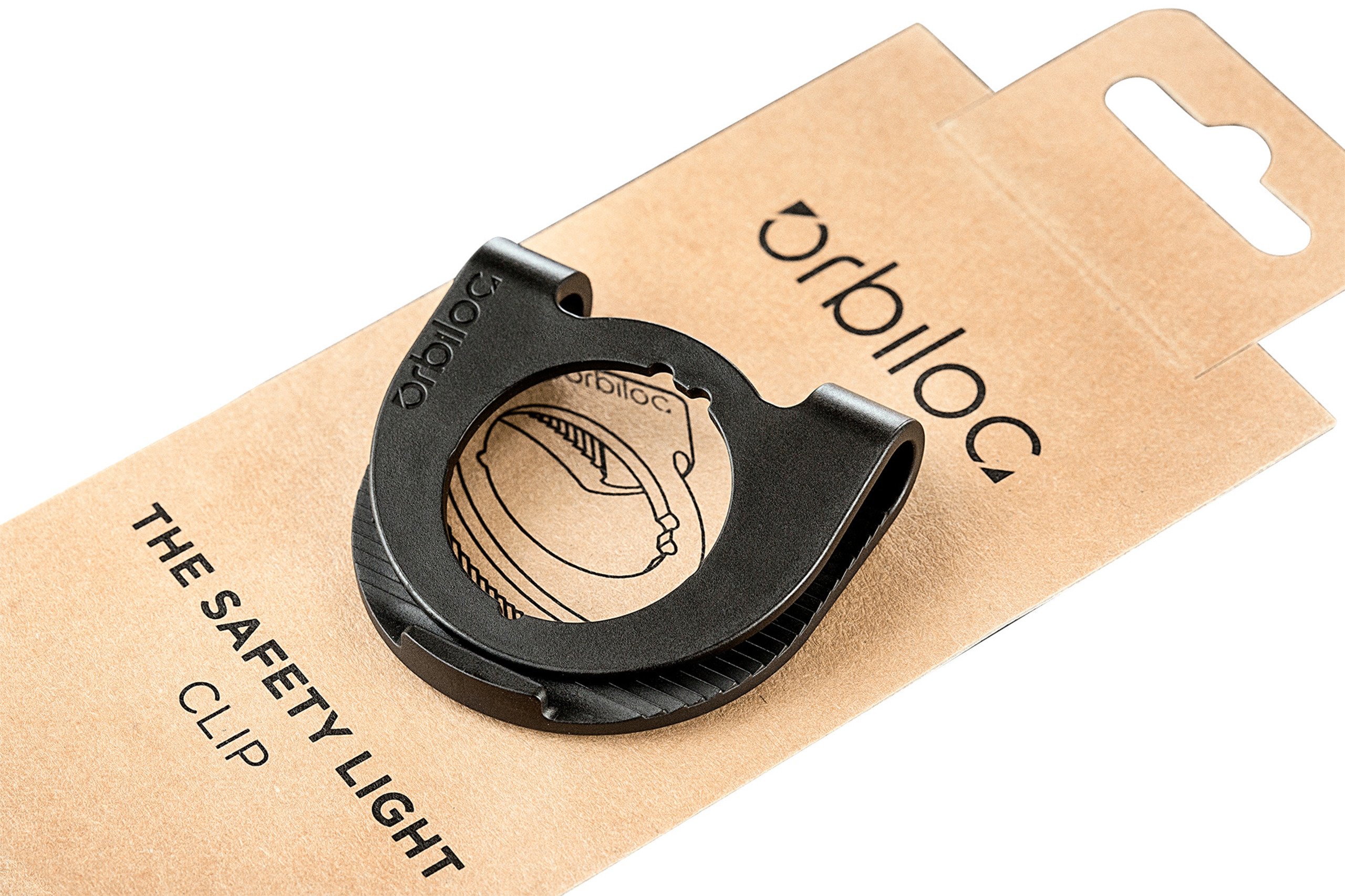 Orbiloc Clip für Safety Light in Originalverpackung aus Karton, zur Befestigung des Sicherheitslichts an Kleidung, Geschirr oder Ausrüstung.
