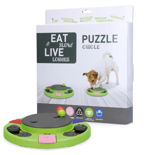 Eat Slow Live Longer Puzzle Circle – grünes Intelligenzspielzeug für Hunde mit drehbaren Elementen, abgebildet mit Verpackung und Hund beim Spielen.