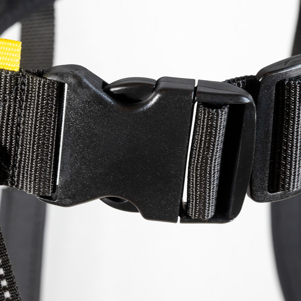Detailaufnahme einer schwarzen Kunststoffschnalle mit Gurtband am Zughundegürtel auf weißem Hintergrund